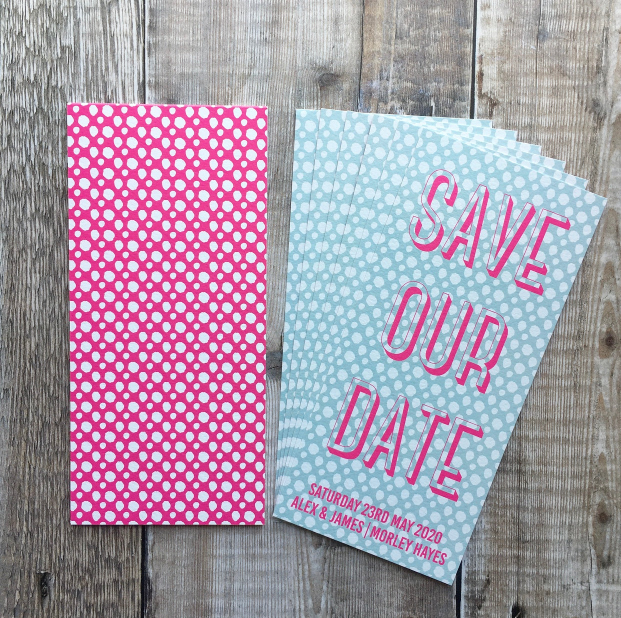 Front and back view. Back (left) has fluorescent pick background, with spotted white pattern, and no text.  Front (right) has a pale blue background, with a white spotted pattern. Text is typographic, and written in fluorescent pink. Bookmark-style wedding invitation/save the date. 99mm x 210mm.